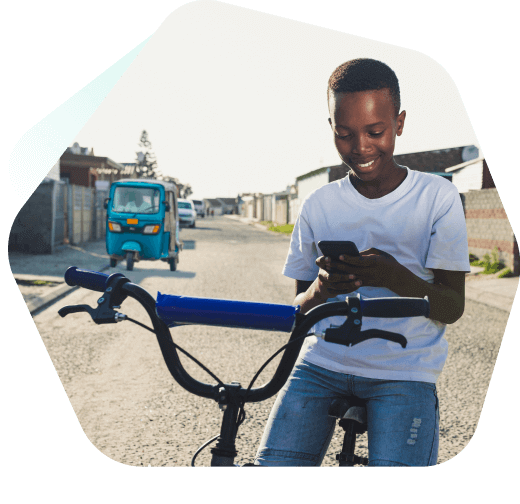 Young boy on his bike using his mobile phone