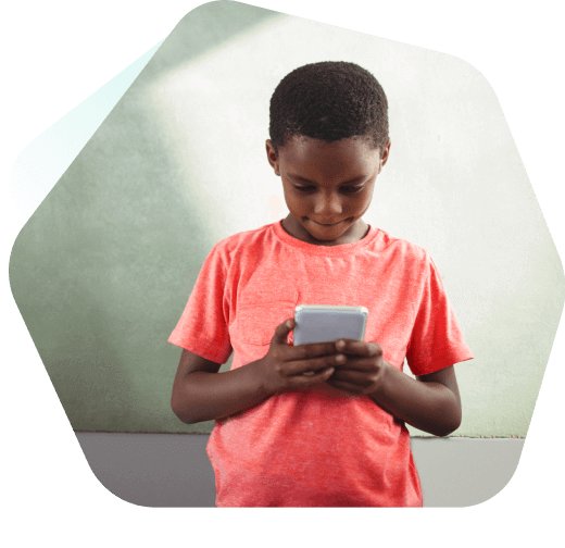 Young boy watching videos on a mobile phone outside